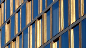 Golden window frames on a high office building, with blue sky reflection in glass panes, on a bright sunny day - abstract pattern in luxurious modern architecture, headquarters of wealthy corporation. - Powered by Shutterstock - Get 15% off with code: PIKWIZARD15