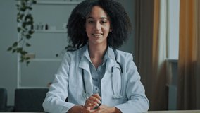 Young african woman doctor therapist talk conference video call consult patient online looking at webcam internet medical consultation use distant teach medic health service give professional advice - Powered by Shutterstock - Get 15% off with code: PIKWIZARD15