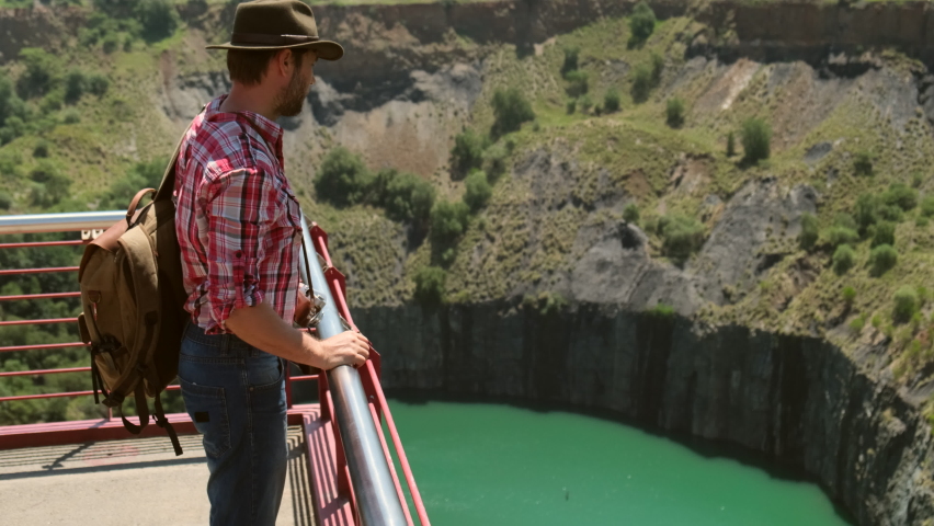 oading minerals copper, silver, gold, and other at mining quarry. Old gold mine underground tunnel. a male traveler with a backpack takes pictures of a quarry after mining gold and diamonds