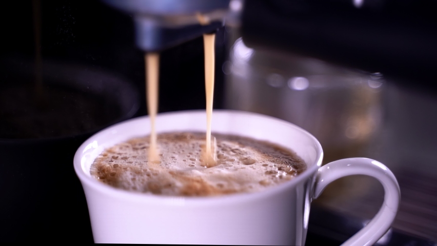Close-up of Coffee foam. espresso crema comes out of the fully automatic coffee machine, Making the coffee machine into a cup. soft focus. | Shutterstock HD Video #1097217779