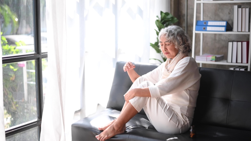 Old woman sit Depression haired  pensive glance Standing with bottle pills and pills by window and anxiety Copy space.  | Shutterstock HD Video #1097218105