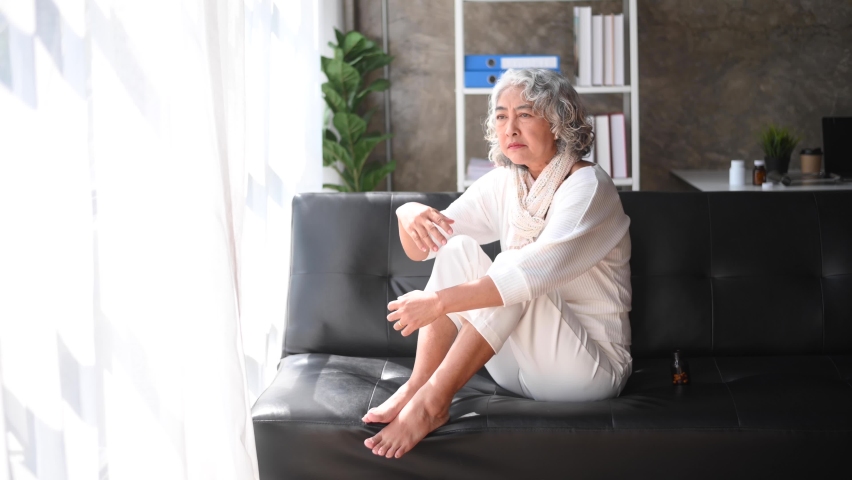 Old woman sit Depression haired  pensive glance Standing with bottle pills and pills by window and anxiety Copy space.  | Shutterstock HD Video #1097218115