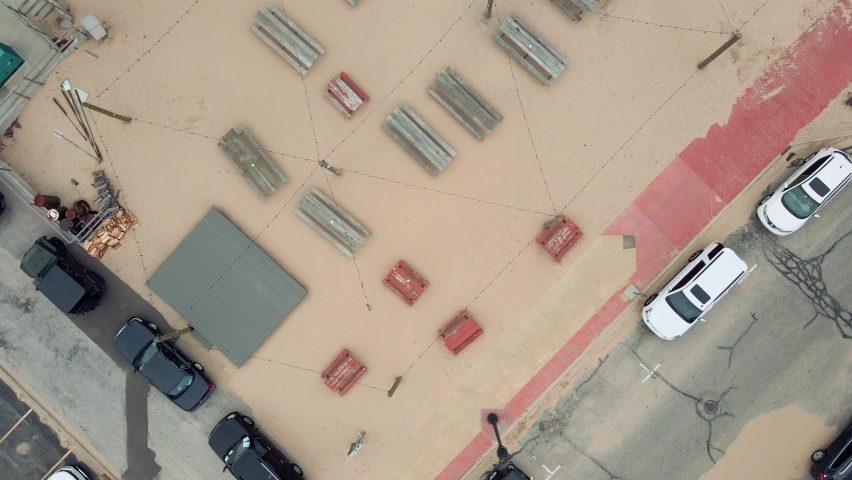 A sandy park with lights and benches.