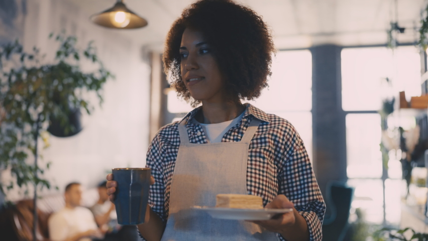 African American waitress serving coffee and dessert to customer in cafeteria