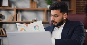 Portrait of handsome millennial arabian business man talking using laptop computer having video conference call virtual meeting, negotiation remote working doing online presentation in office.