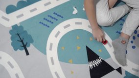 A Kid is Playing with the Toy Cars on the Carpet. The Toy Cars are Riding on the Road. - Powered by Shutterstock - Get 15% off with code: PIKWIZARD15