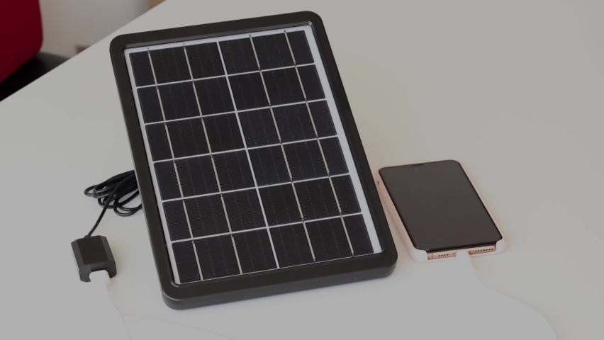 Small solar panel charges the phone. | Shutterstock HD Video #1097226979