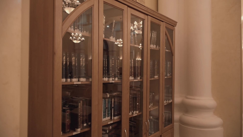 Modern Jewish library in Synagogue. Bookshelves with volumes. Traditional books in Judaic library: Torah, Talmud. Historic building of Jewish community. House of Jewish Spirituality and Divine Law.