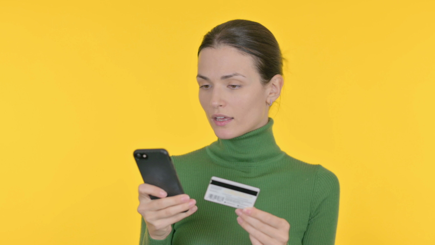 Beautiful Woman Shopping Online on Smartphone on Yellow Background  | Shutterstock HD Video #1097231735