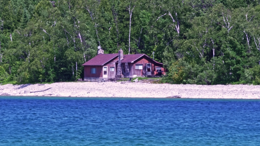 Cottages at limestone rocky cliff with green forest by Lake Huron Lion