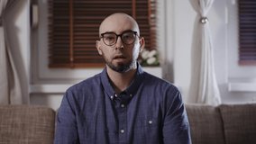 Web conference and remote work. Portrait of young Caucasian handsome bearded bald man talking on video call. Unrecognisible person invades at screen. Concept of freelance and online interview.