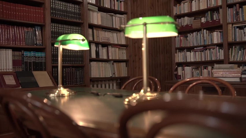 Modern Greek library with banker’s lamps on tables in a Culture Centre. Bookshelves with volumes: ancient philosophy, poems, legends and myths. Museum of Spirituality and Wisdom of a Greek community.