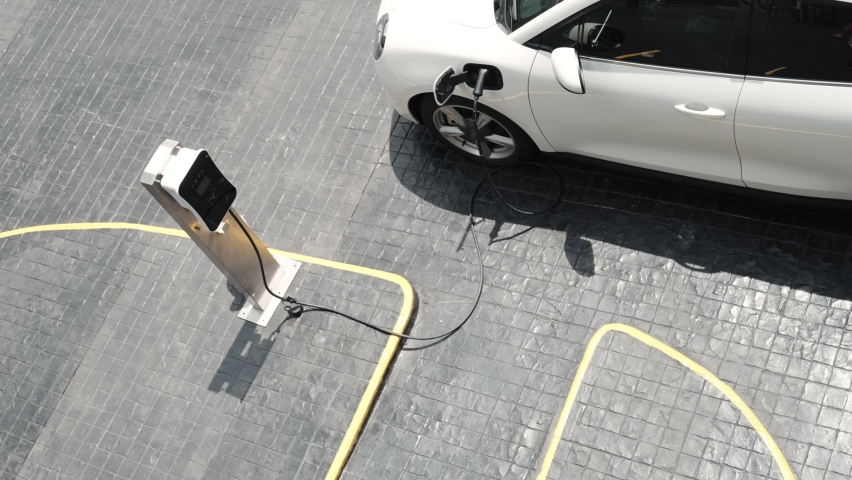 Progressive innovation urban electric on-street charging station with electric vehicle battery being charged with green energy for environmental concern in order to reduce CO2 emission. | Shutterstock HD Video #1097241055