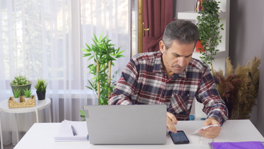 Stressed man looking at bills feeling worried about financial problem.
Stressed man desperately looking at debts and bills thinking how to pay.
 | Shutterstock HD Video #1097243021