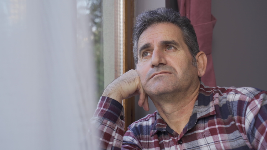 The man is at home watching out the window and is thoughtful.
Mature man looking out the window.
 | Shutterstock HD Video #1097243121