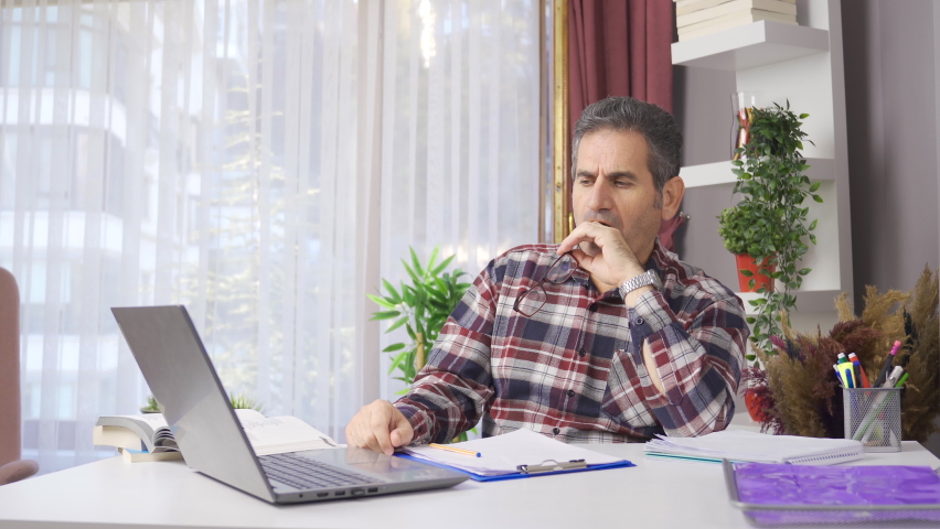 Serious businessman working in his home office.
Businessman in glasses working in home office looking at laptop.
 | Shutterstock HD Video #1097243203