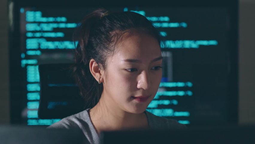 Young Asian woman, developer programmer, software engineer, IT support, working hard at night overtime on computer to check coding in bugging system and running program successful. Royalty-Free Stock Footage #1097245487