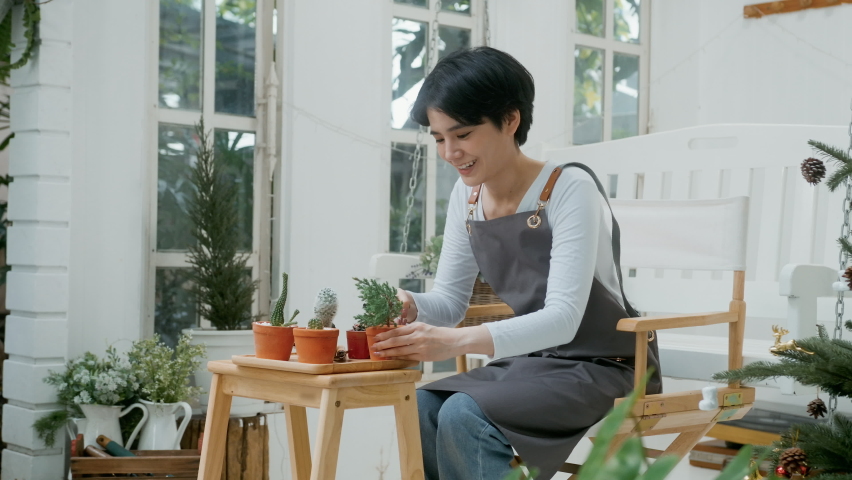 A young Asian woman enjoys gardening at home, Health care and wellbeing concept

