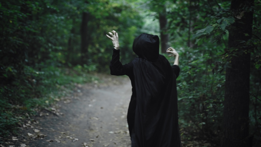 Medieval witch moving along a forest path. Strange convulsions in the woman's movement | Shutterstock HD Video #1097250035