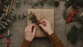 Boxing day, sustainable Christmas floral gift wrapping. Female hands decorating Christmas present.  - Powered by Shutterstock - Get 15% off with code: PIKWIZARD15