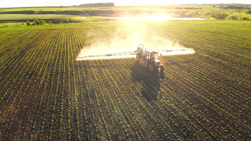 Panoramic shooting quadrocopter in height tractor with trailer for mechanized irrigation field water on large area. Equipment for assistance in agriculture. Cultivation greenery and plants big scale. | Shutterstock HD Video #1097254073