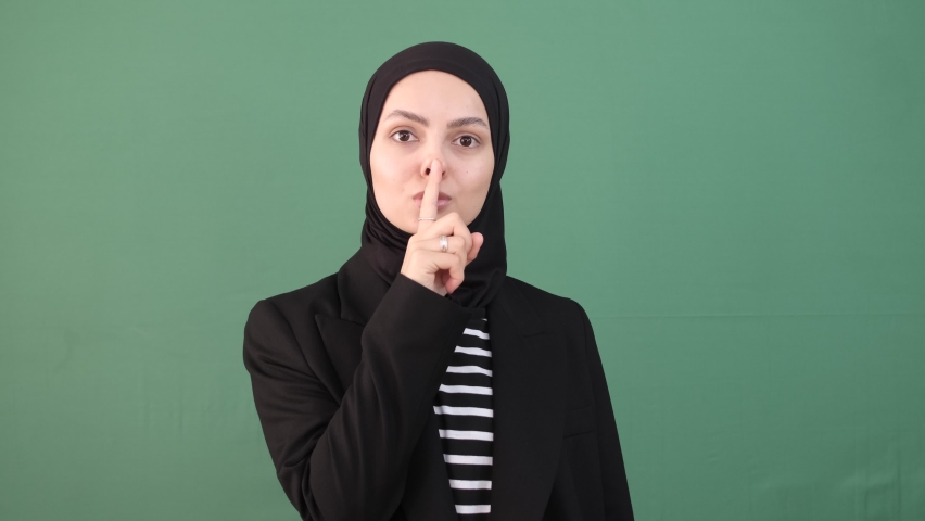 Muslim woman quiet, girl stop speaking in front of chroma key, face expression serious, isolated green background | Shutterstock HD Video #1097255295