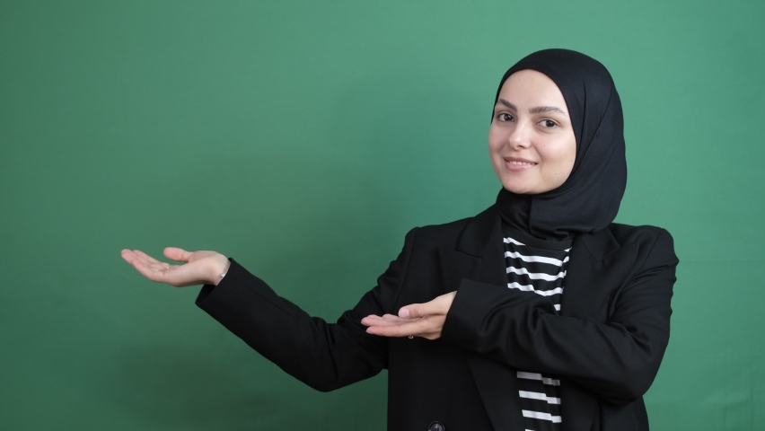 Hijab girl looking right side green screen, girl showing direction in front of chroma key, young person expression smile | Shutterstock HD Video #1097255323