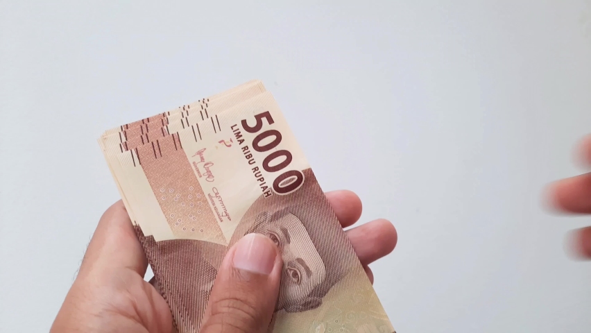 Hands counting Indonesian rupiah money. Five thousand rupiah denomination. | Shutterstock HD Video #1097258343