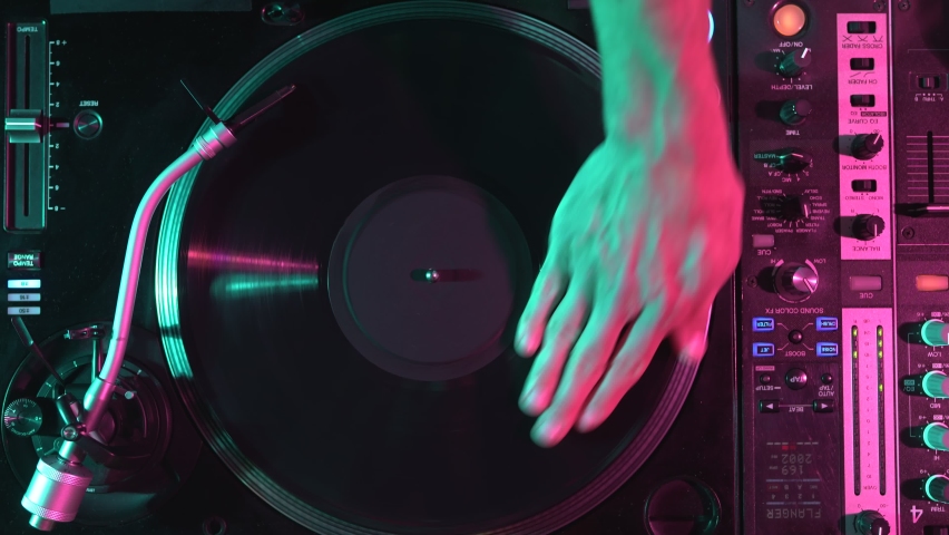 Hip hop DJ scratches vinyl disc on turntable in overhead video clip. Disc jockey hand scratching record with music Royalty-Free Stock Footage #1097263491