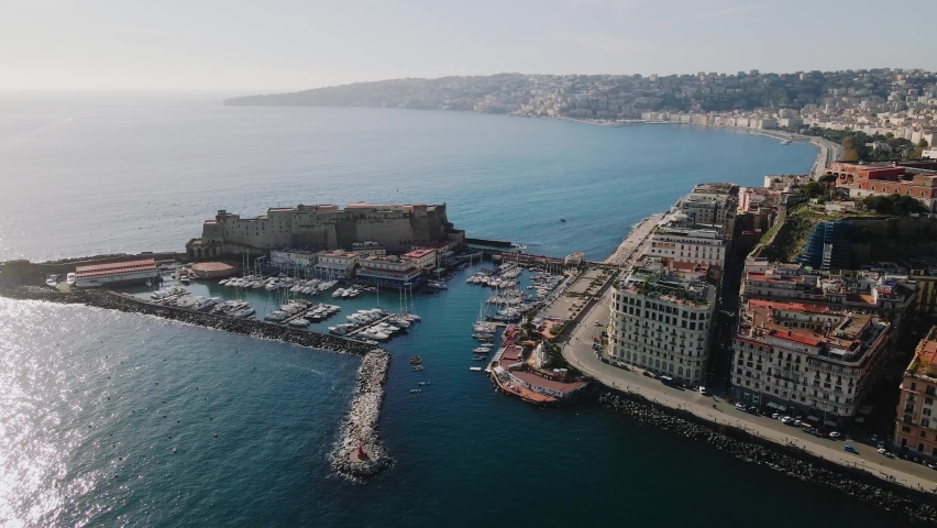 Panoramic drone view of the entire city of Naples in southern Italy. Flight over historical landmarks in Naples, Italy. Historic egg castle (castel dell'ovo) on the waterfront of the Gulf of Naples Royalty-Free Stock Footage #1097266403