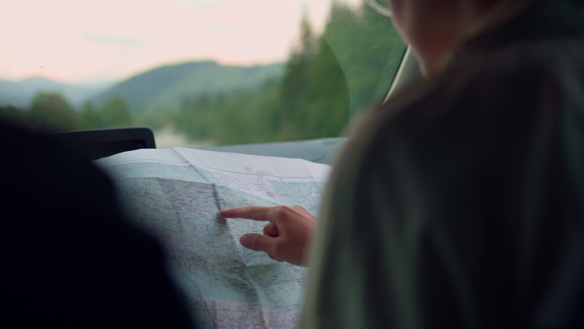 The tourist runs his finger on the map, sits in the car, plans, looks for the right route to travel, travels with his family and spends his vacation alone in the summer while traveling.
 Royalty-Free Stock Footage #1097266437