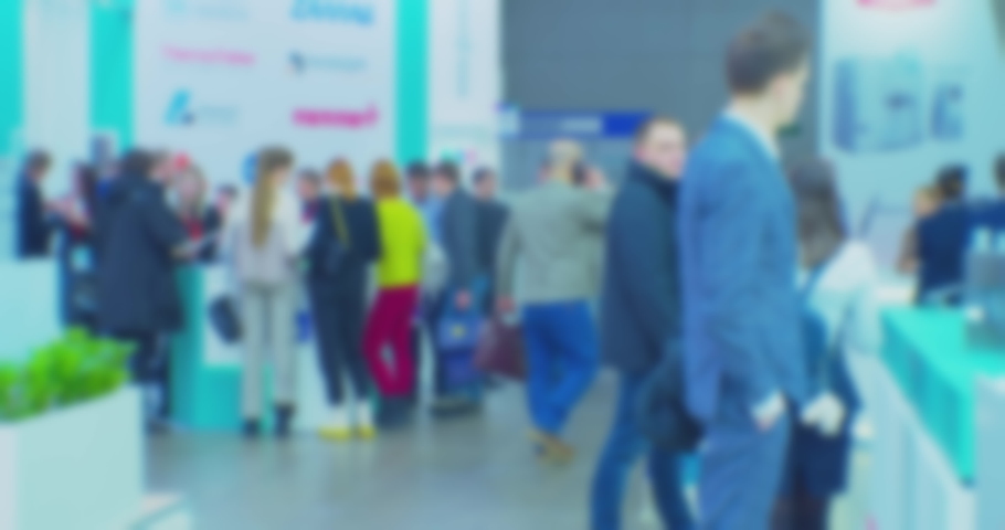 blurred silhouettes of unrecognizable people inside a large modern building.slow motion video.