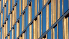 Golden window frames on a high office building, with blue sky reflection in glass panes, on a bright sunny day - abstract pattern in luxurious modern architecture, headquarters of wealthy corporation. - Powered by Shutterstock - Get 15% off with code: PIKWIZARD15