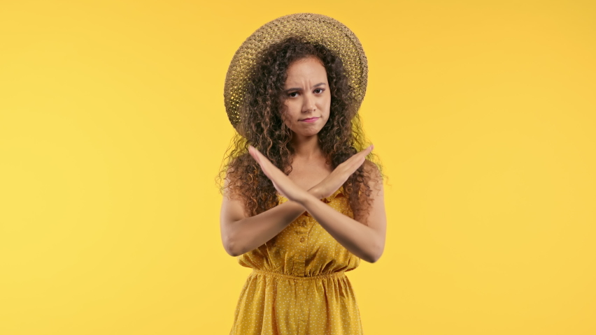Dissatisfied woman disapproving with no finger warning sign, making negation gesture. Denying, rejecting, disagree. Portrait of young lady on yellow background. | Shutterstock HD Video #1097268549