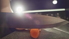 Slow motion video close-up of cutting carrots into circles on a cutting board. Chef cutting vegetables for salad in the kitchen. High quality 4k footage