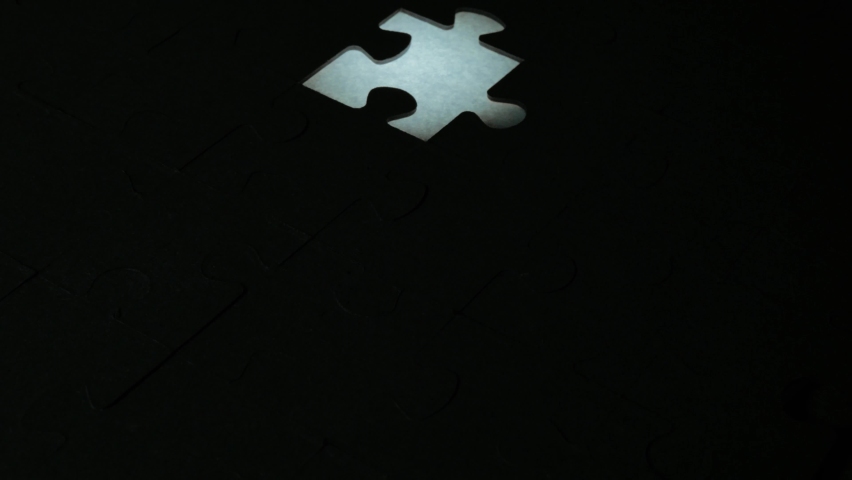close-up view of puzzle pieces with the last one at the center in different color, concept of teamwork, leader and success.