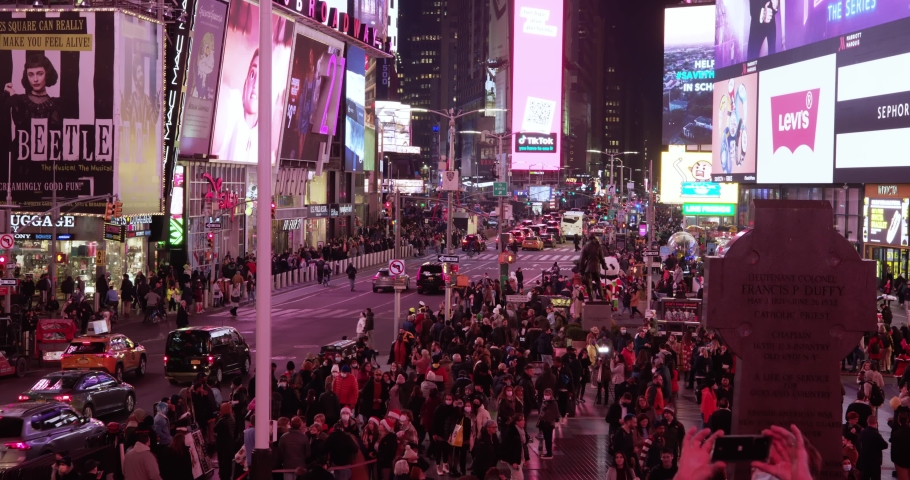 Manhattan, USA - 2. December 2021: Crowded times Square at night in Manhattan, New York City. Bright displays illuminate Times Square, New York. High angle view 4K