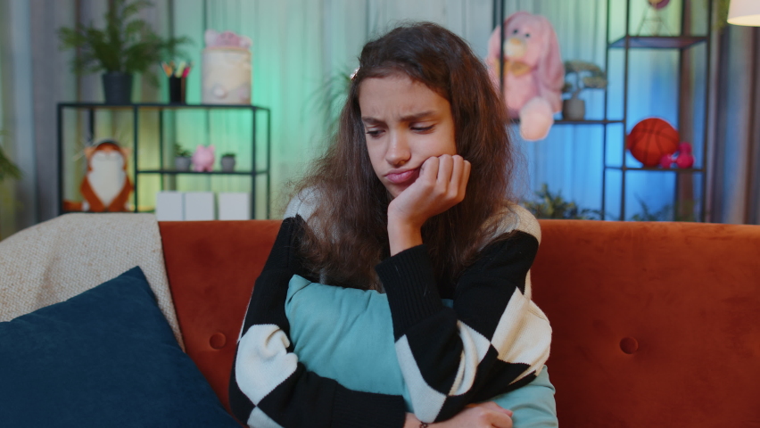 Sad lonely preteen girl at home looks pensive thinks over life concerns or unrequited love, suffers from unfair situation. Young child, kid problem, break up, depressed feeling bad annoyed burnout