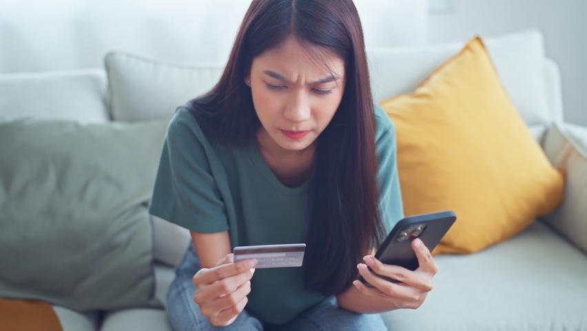 Upset asian woman using smart phone and holding mockup credit card try make transaction payment purchase feels stressed due lack of funds, zero balance, scam and fraud, financial problem concept | Shutterstock HD Video #1097280923