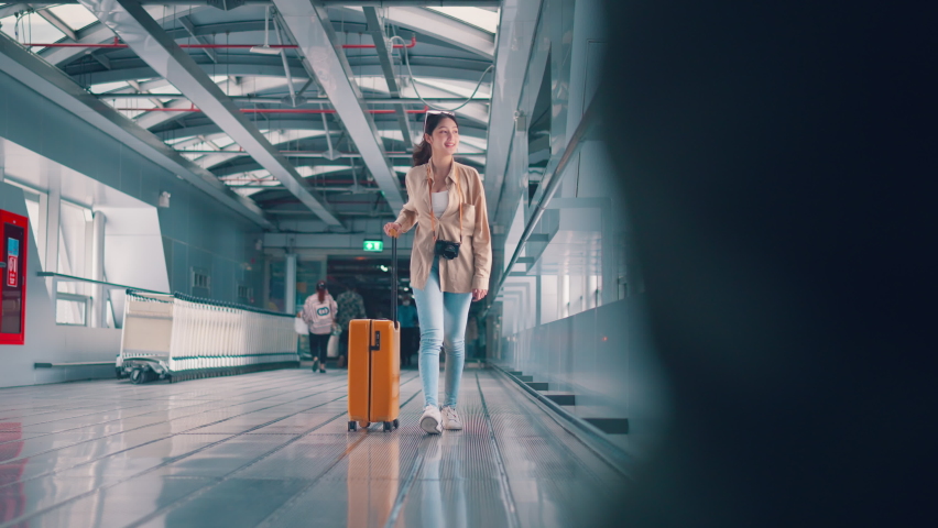 Happiness smiling asian woman passenger walking with a yellow suitcase luggage at airport terminal, Woman on way to flight boarding gate, Tourist journey trip concept Royalty-Free Stock Footage #1097281713