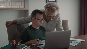 Caucasian man with down syndrome learning with his mum at home. Shot with RED helium camera in 8K.   