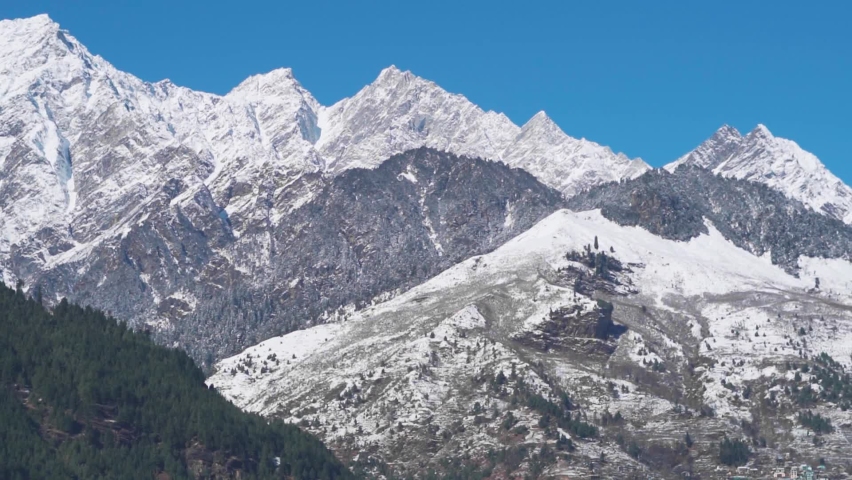 View of snow covered mountains after snowfall during the winter season at Manali in Himachal Pradesh, India. Himalayan Mountains covered by snow after snowfall. Nature background with copy space. | Shutterstock HD Video #1097282401