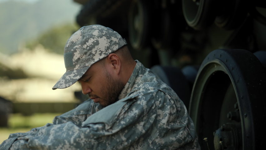 Commander Army soldier military defender of nation in uniform siting near battle tank while state of war. Serious man in military uniform special forces soldier standing against on field Mission.