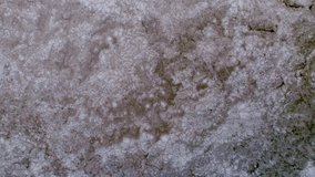 Drone footage from a bird's eye view of a frozen lake, which is starting to melt. Aerial video. 4K.