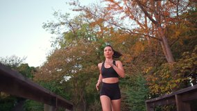 Middle age woman jogging warm autumn day in city park wooden bridge. Caucasian female athlete running outdoor. Healthy lifestyle. Morning jogger training. Fit woman jogging outside low angle view - Powered by Shutterstock - Get 15% off with code: PIKWIZARD15