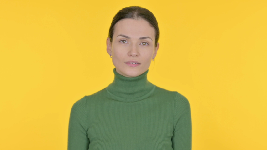 Successful Beautiful Woman Celebrating Achievement on Yellow Background 