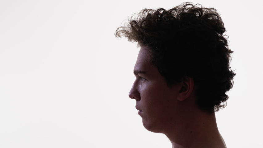 Serious man. Profile portrait. Conscious mind. Calm concentrated silhouette guy with curly hairstyle looking copy space on white advertising background. | Shutterstock HD Video #1097289777