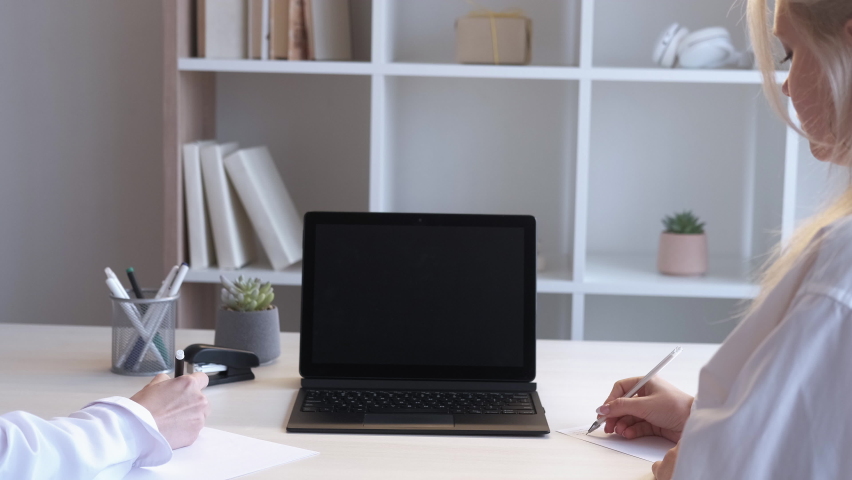E-learning course. Video call. Distance education. Female students taking notes watching online lesson on mockup laptop with black blank screen at home workplace. | Shutterstock HD Video #1097289795