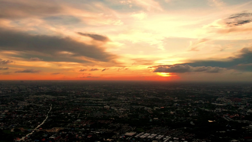 Beautiful sunset on coastline tropical beach with golden sea and silhouette travel people on nature background, Ocean sunset timelapse, fly in clouds, sun going beyond the horizon illuminating water