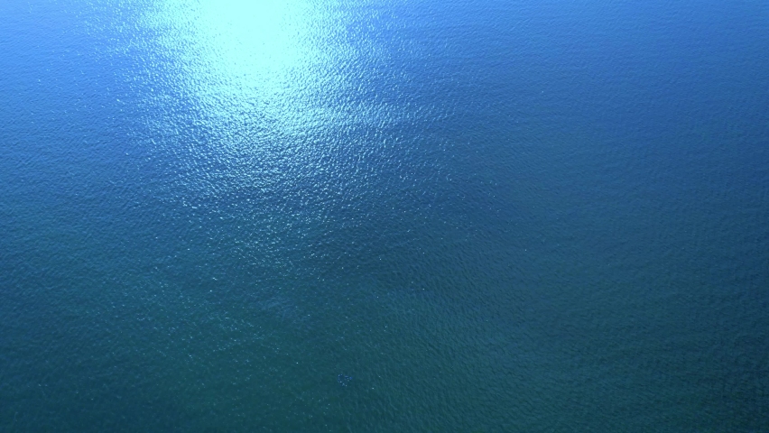 Beautiful sunset on coastline tropical beach with golden sea and silhouette travel people on nature background, Ocean sunset timelapse, fly in clouds, sun going beyond the horizon illuminating water